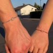 Paar Hand in Hand auf der Straße mit Liebesknoten Armbändern