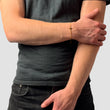 Kreuz Armband in Gold, Hand am Arm