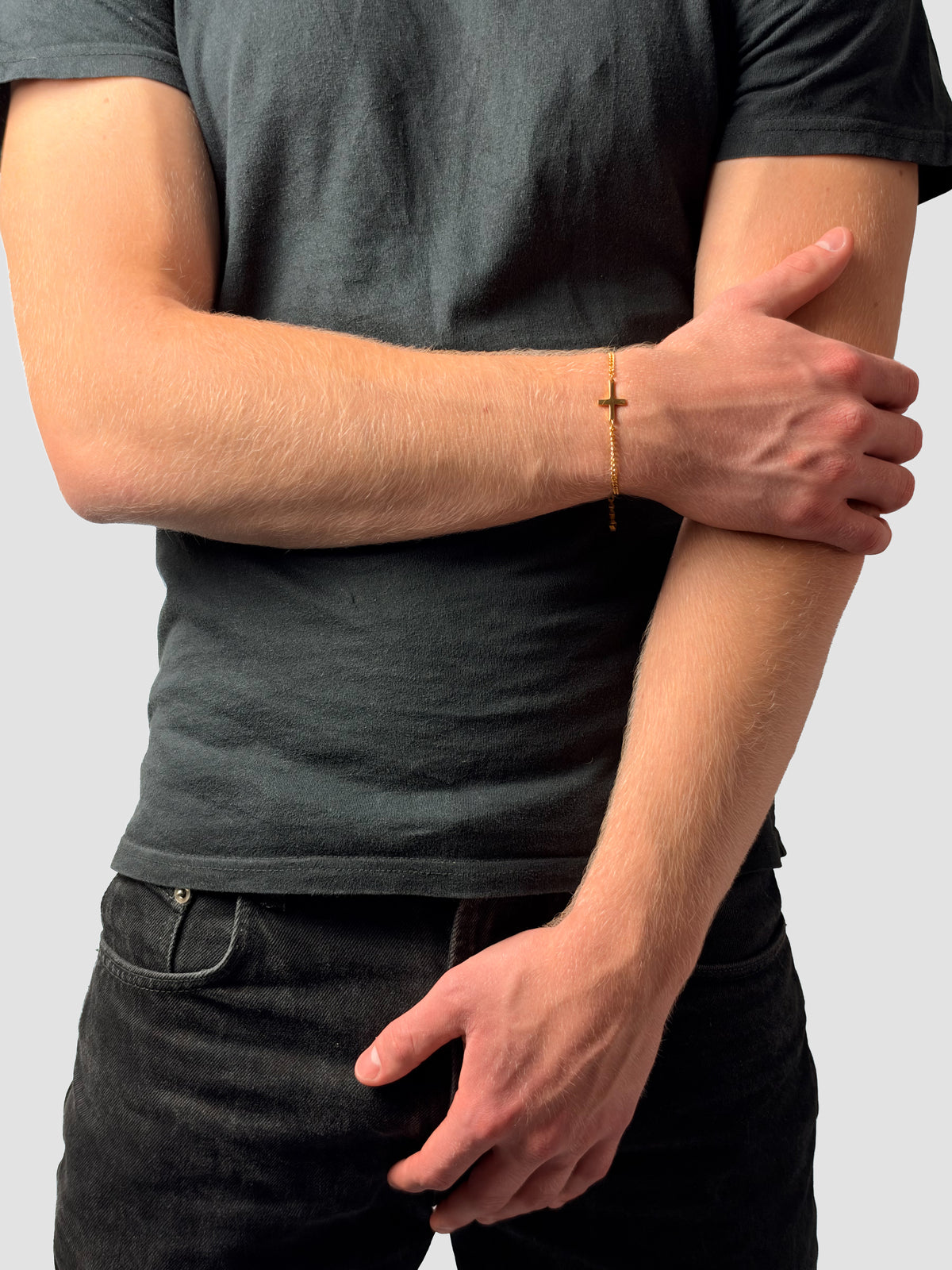 Kreuz Armband in Gold, Hand am Arm